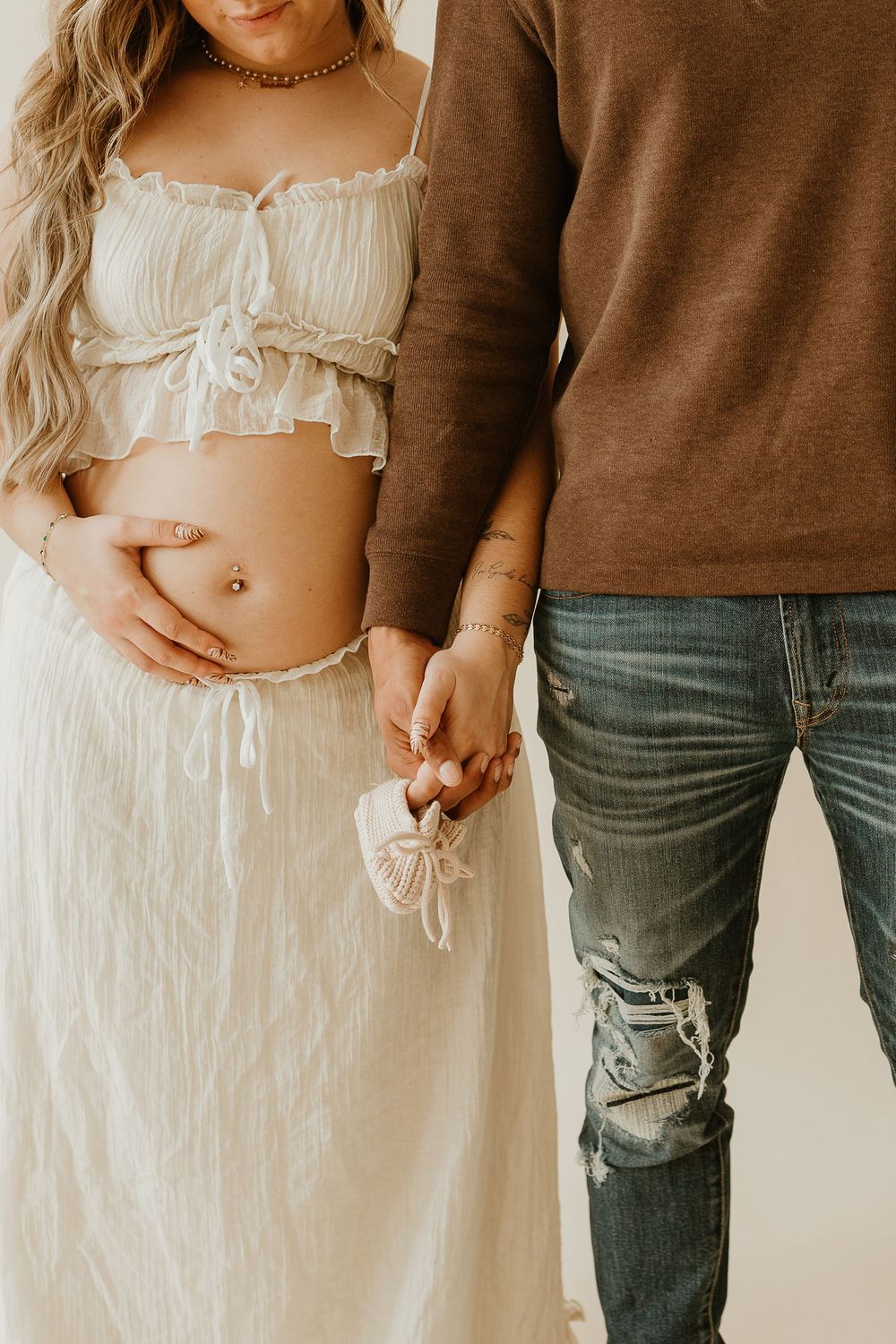 A romantic maternity photo series showing close-up shots of a couple in casual attire against a neutral background.