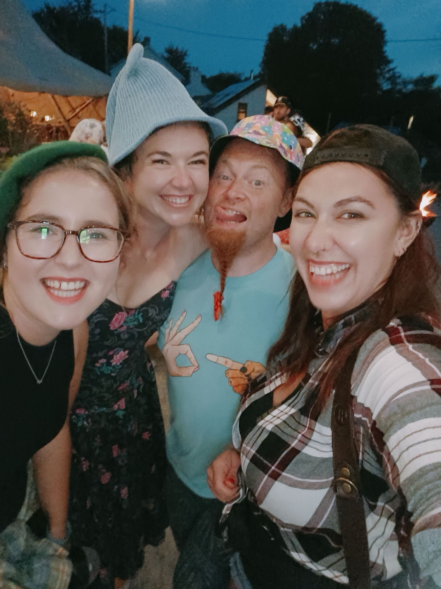 Group of friends wearing baseball caps pose together for a casual photo.