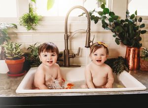 Five connected photos showing children playing and bathing in a white bathtub with plants and decor visible in background.
