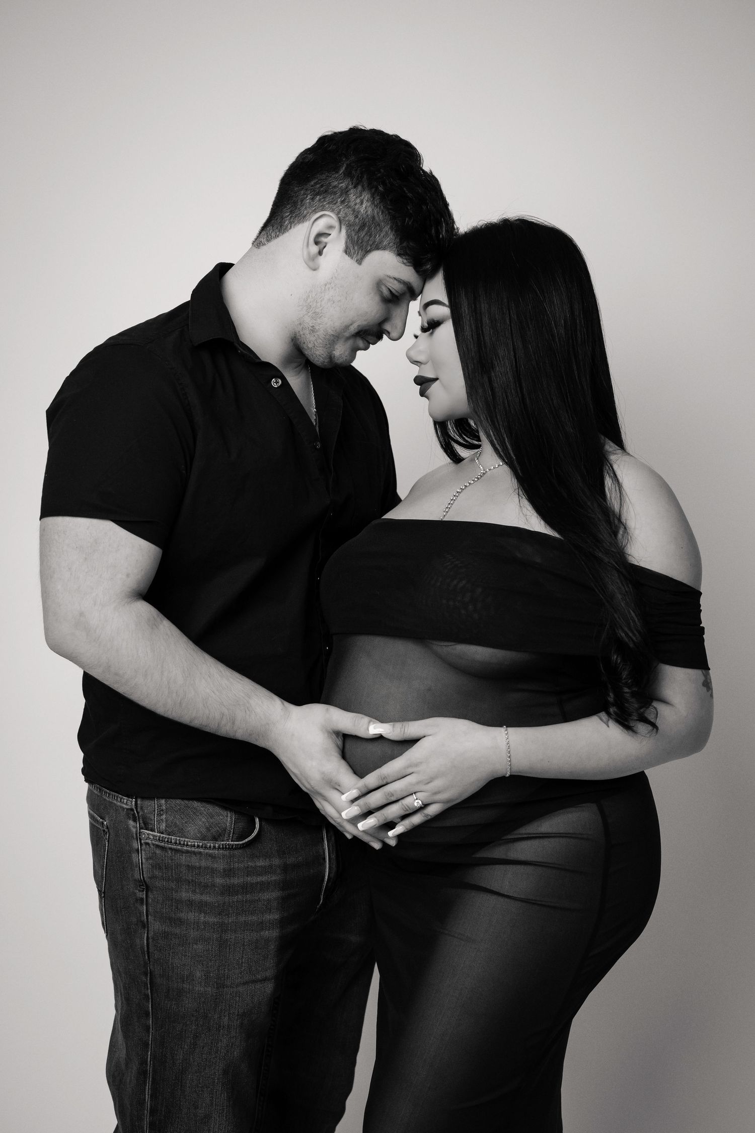 Black and white maternity photography captures intimate moments between expectant parents.