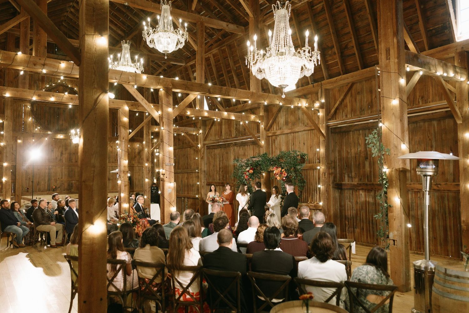 Main Yost Barn wedding venue interior with chandeliers and rustic beams near Rochester NY.