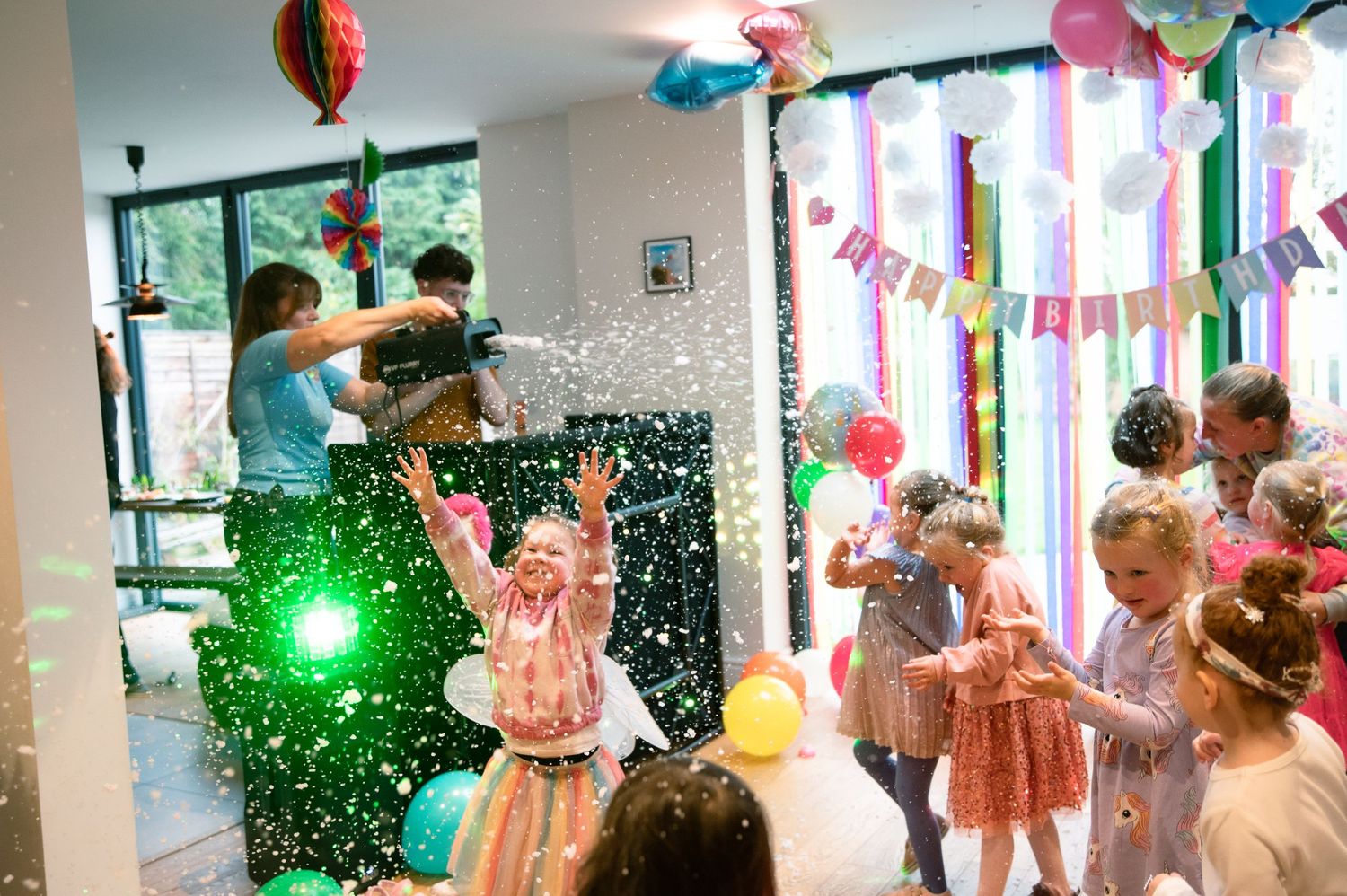 A birthday party celebration with confetti, balloons, and colorful decorations as children gather for a fun indoor event.