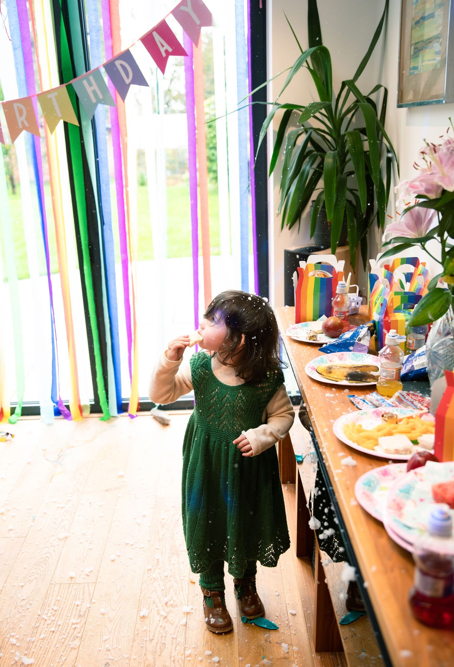 A decorated party room with colorful streamers, a festive banner, and a long table set up for a celebration.