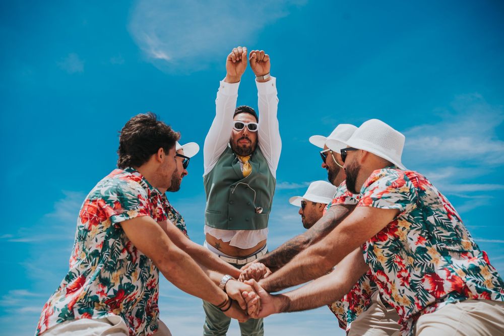 Synchronized dancers perform an upbeat dance routine against a bright blue sky backdrop.