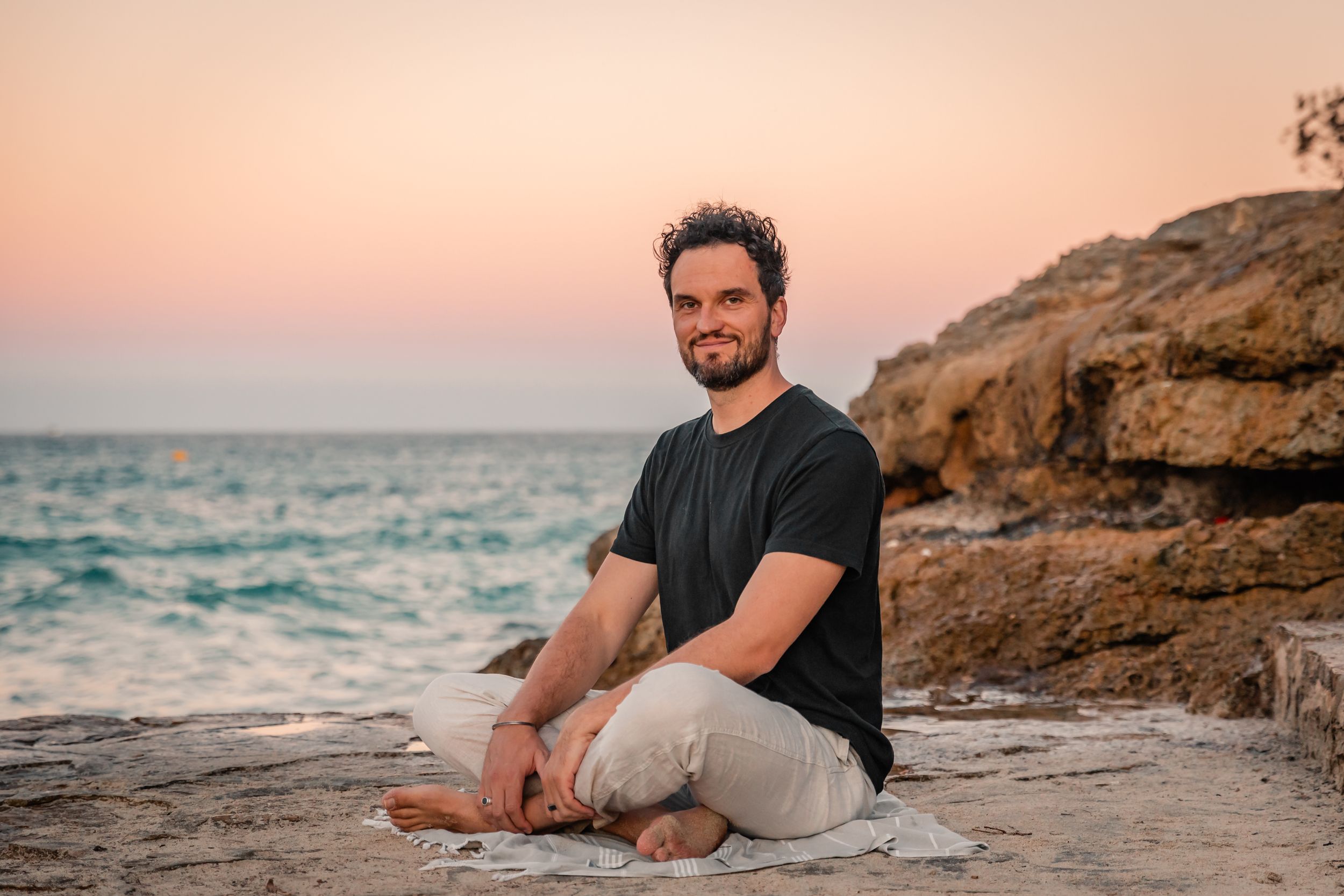 branding photography session by sunset of man sitting by the sea at Cala Mendia Mallorca