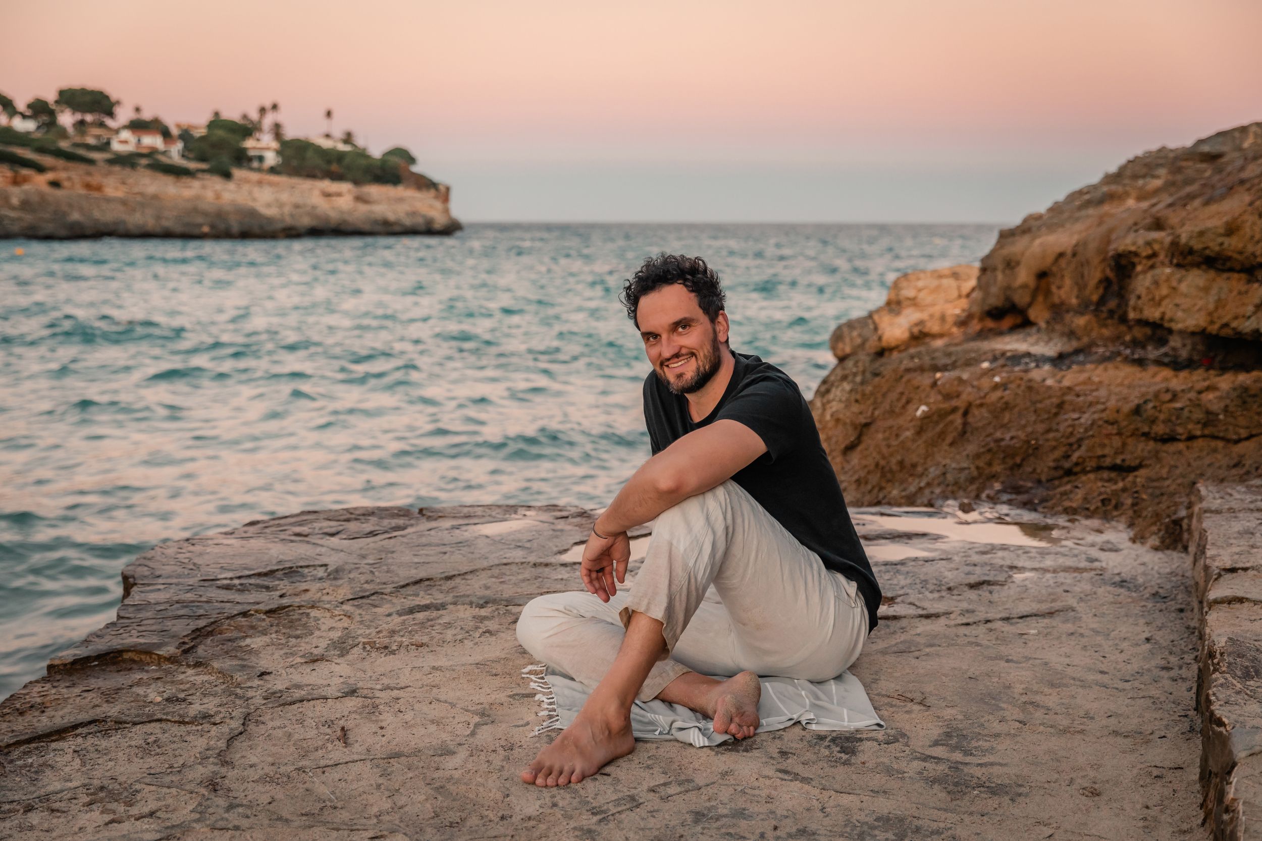 branding portrait session of man sitting by the sea at Cala Mendia Mallorca.