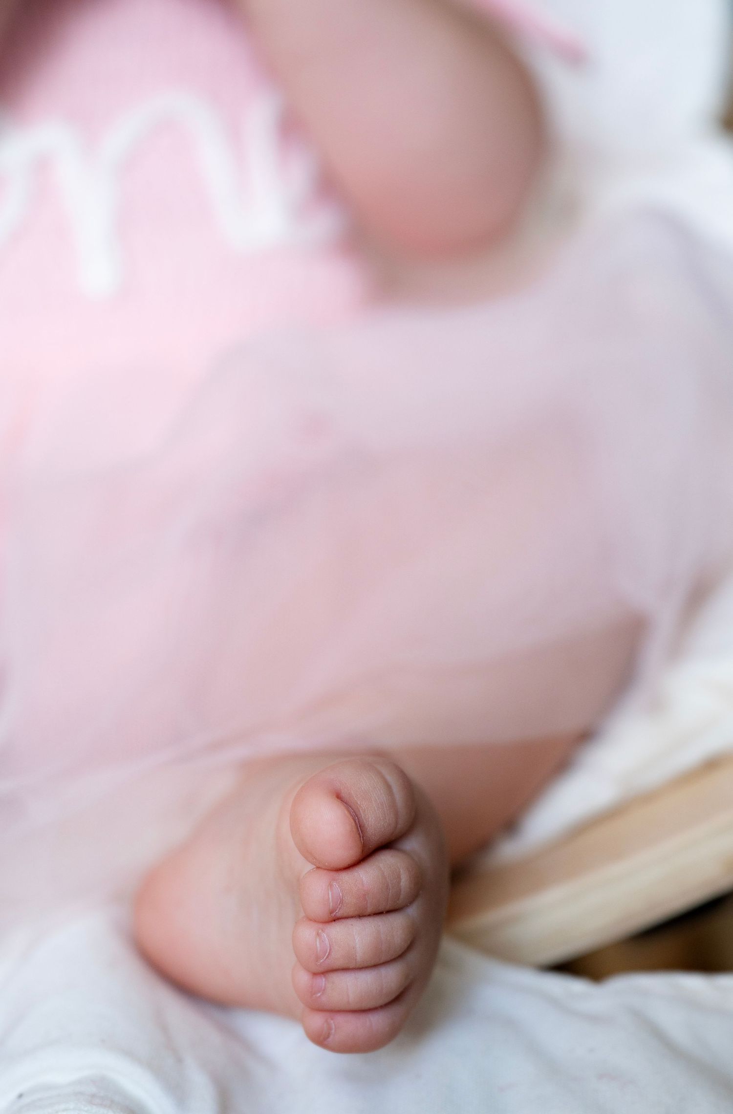 Close-up series of a newborn baby's tiny hand on white bedding showing delicate details and soft lighting.
