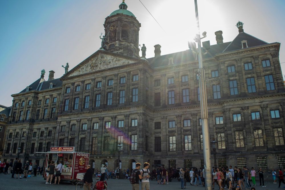 Royal Palace on Dam Square in Amsterdam glowing in late afternoon sunlight.