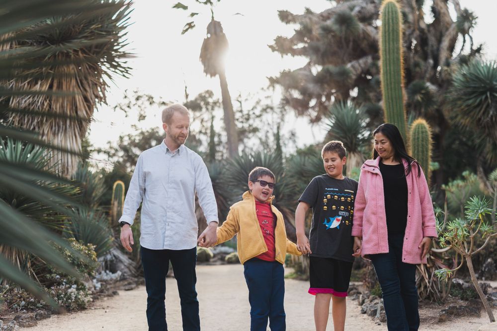 Family walking together on a path surrounded by desert plants and cacti.