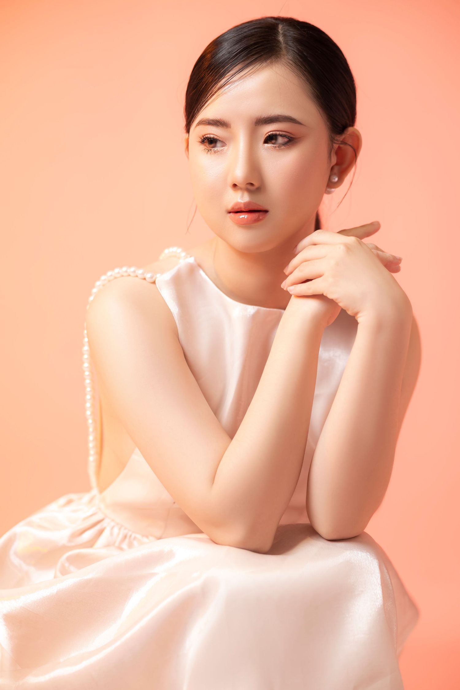 Artistic portrait of woman in olive green dress against blue studio backdrop