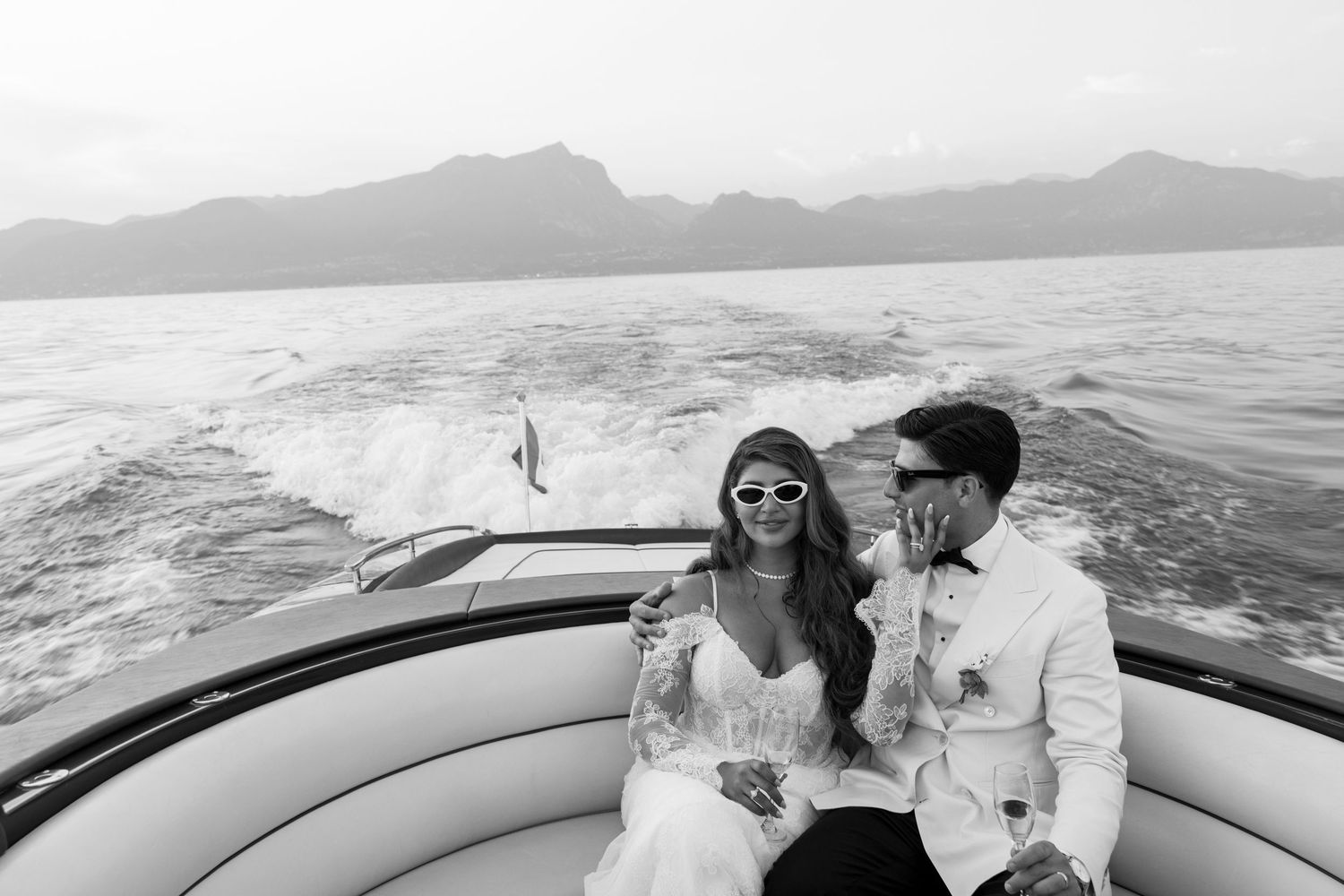 Romantic vintage-style scene with couple on vespa in black and white.