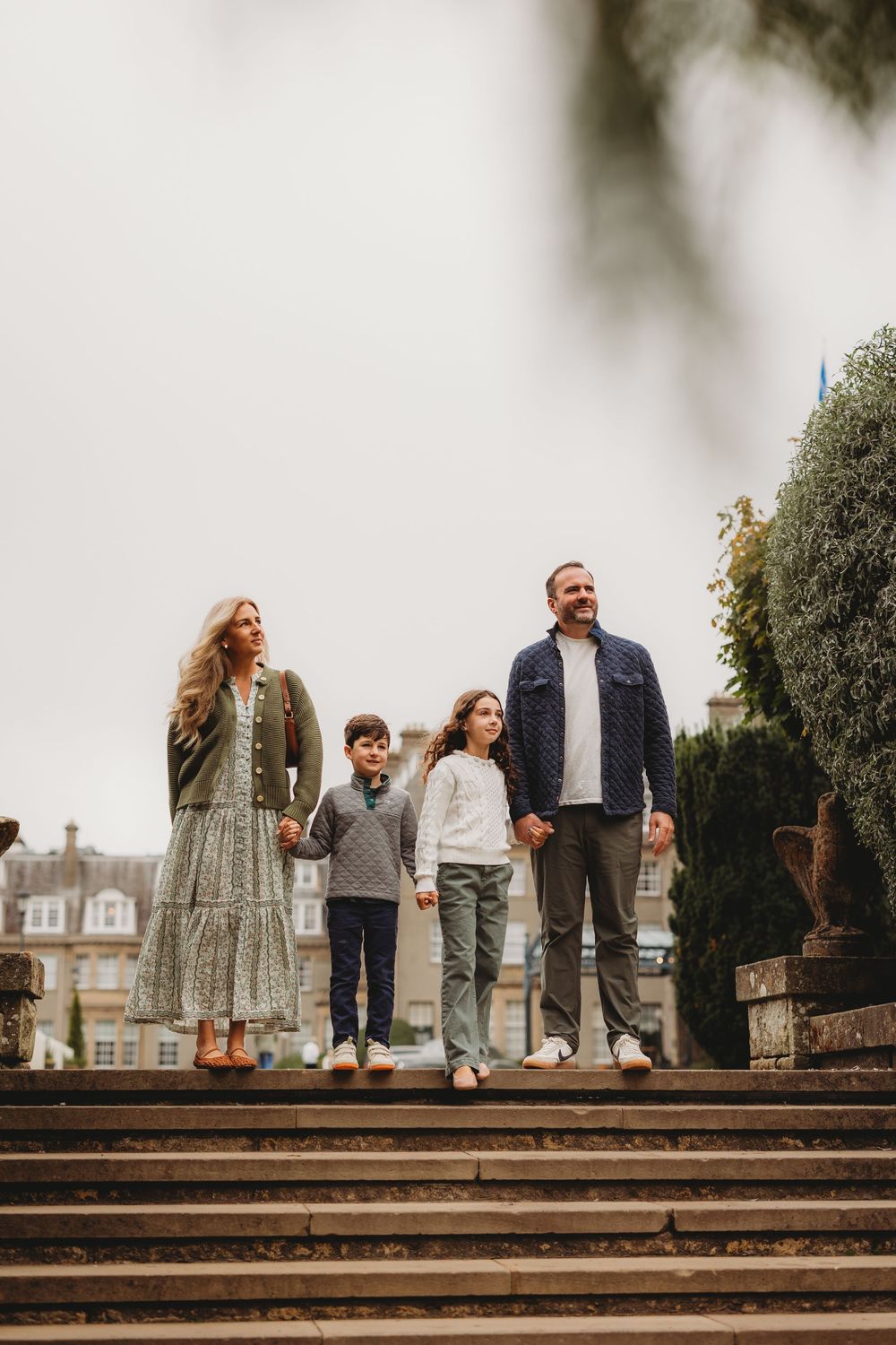 Group standing together on stone steps outside a historic building on an overcast day.
