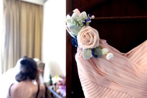 Pink bridesmaid dress with delicate floral corsage detail.