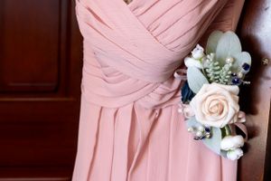 Close-up of pink bridesmaid dress with rose and baby's breath corsage.