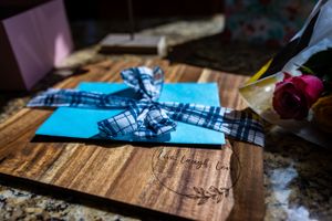 Blue wedding invitation cards arranged on rustic wooden surface.