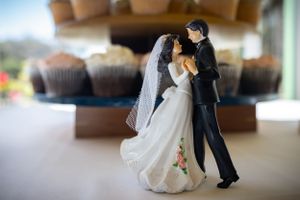 A decorative wedding cake topper featuring a dancing couple in traditional wedding attire.