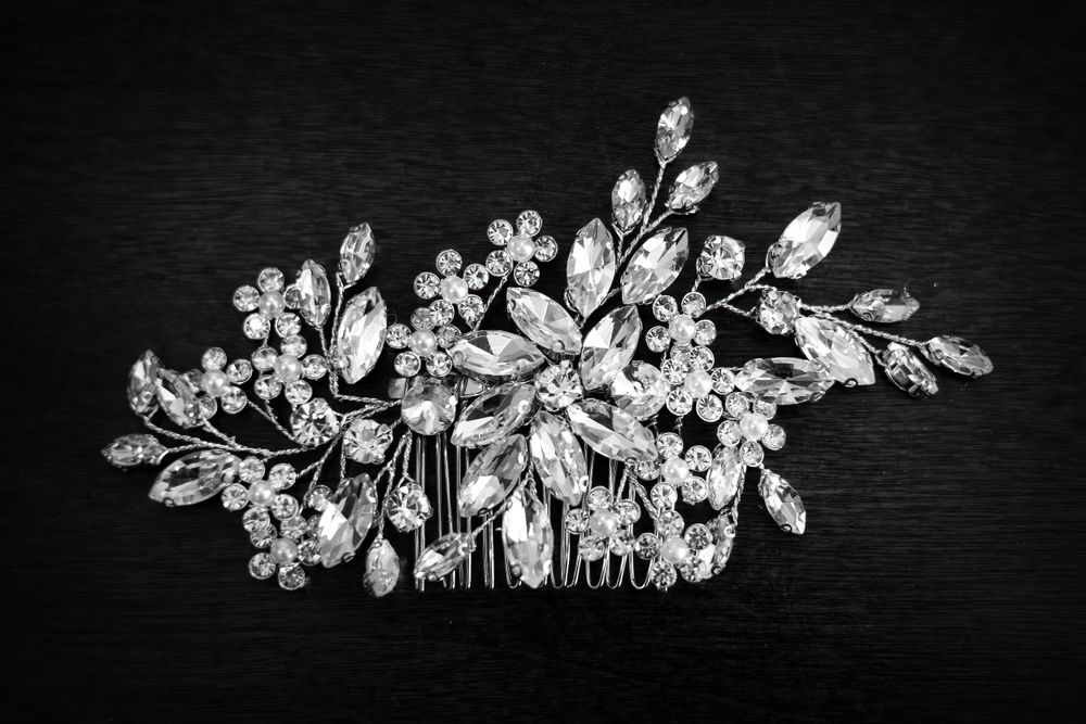 Elegant crystal and pearl floral hair accessory photographed on dark background.