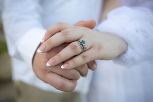 Close-up of hands showing an engagement ring with soft focus.
