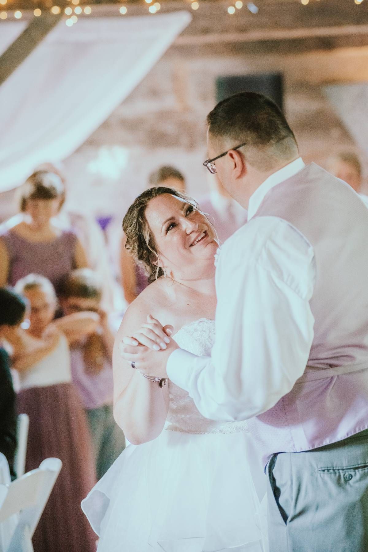 a bride and groom staring lovingly at each other as they dance during their wedding song