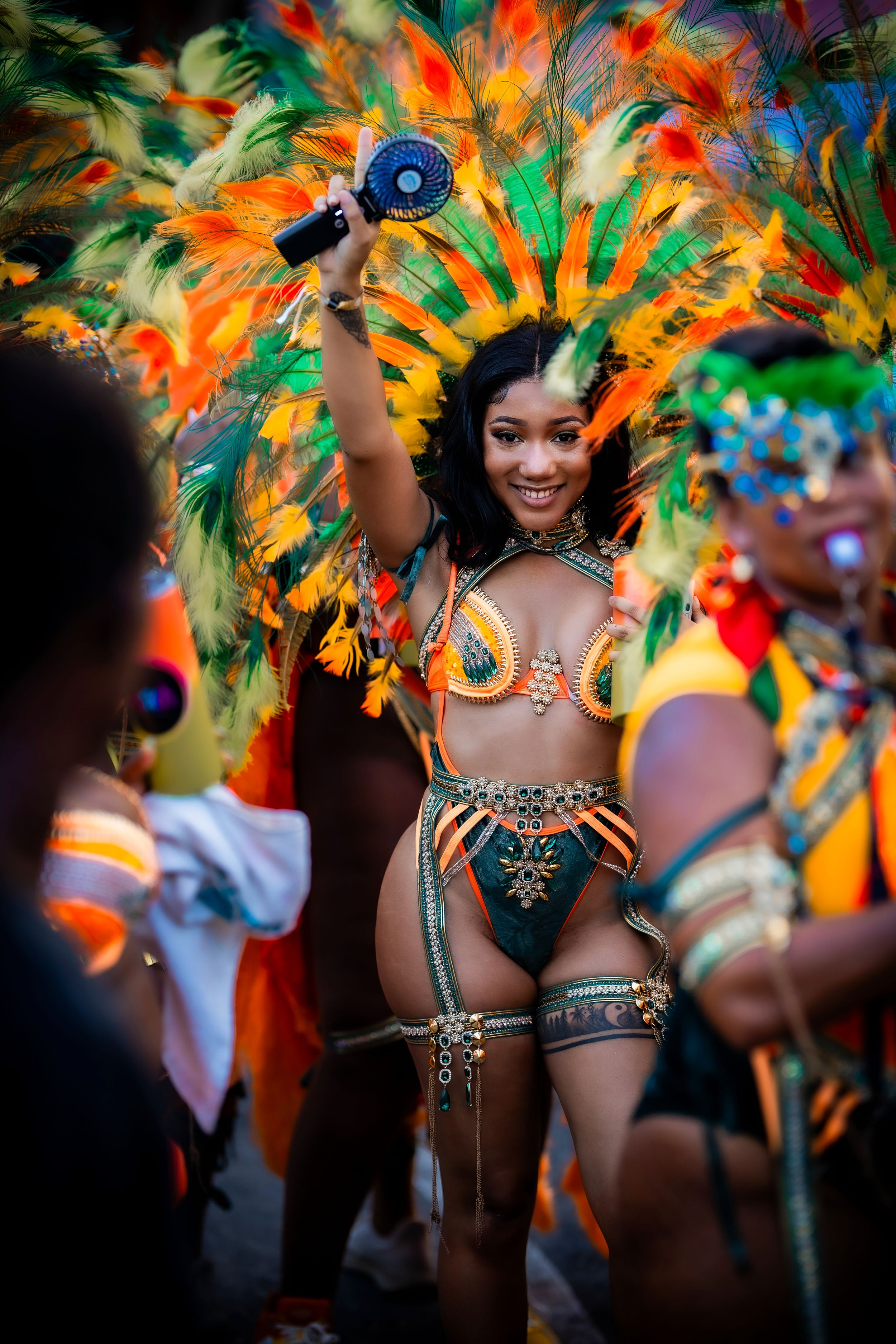Antigua Carnival performer with multicolor orange and green wings — event portrait by Timoy B Photography.