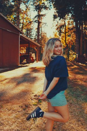 Photo of girl enjoying sunshine, smiling, looking at camera.