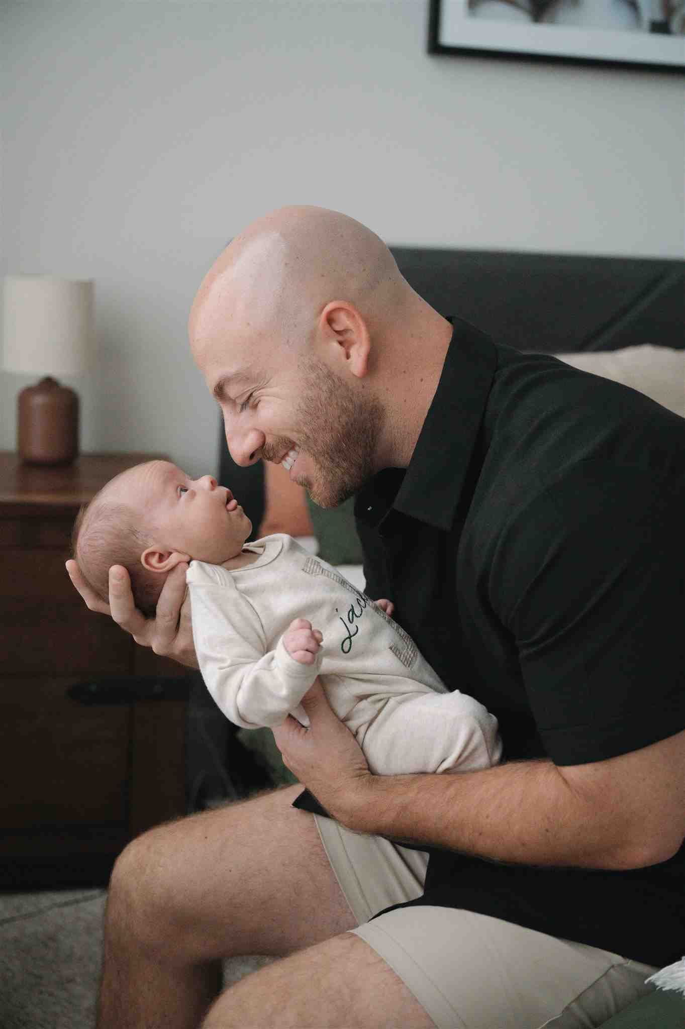 A tender moment shared between parent and baby at home as they smile together in close interaction.