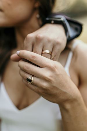 Elegant wedding rings and smartwatch detail shot on bride's hands.