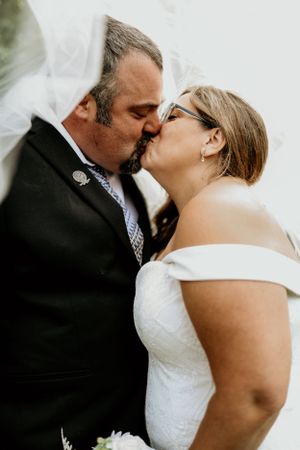 Intimate wedding moment captured between couple in formal attire.