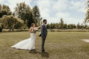 Wedding first look moment in sunny outdoor garden setting.