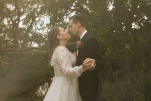 Emotional wedding moment captured during an outdoor ceremony with greenery in the background.