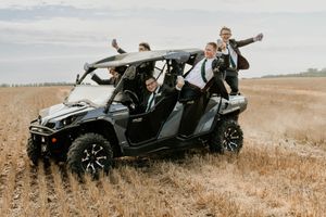 A black off-road utility vehicle parked in a golden wheat field on a cloudy day.