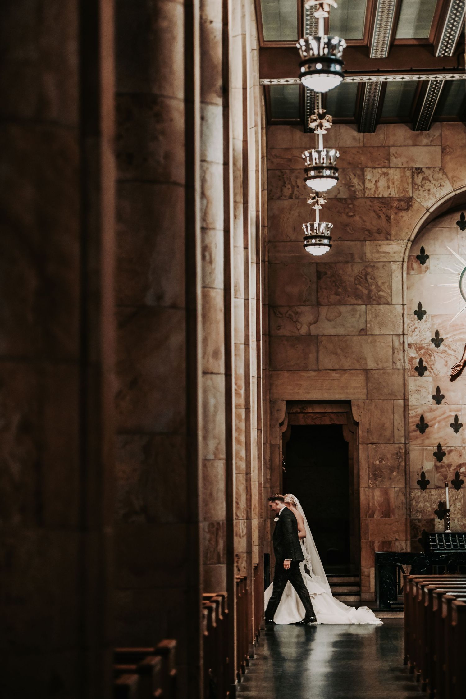 bride and groom walk through their cathedral at their dallas wedding