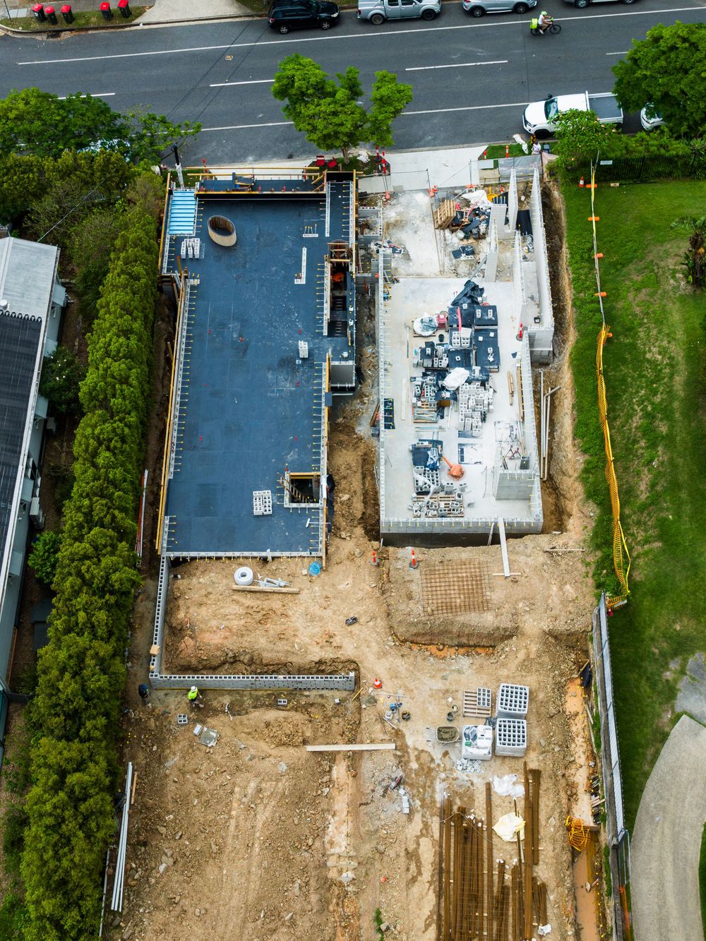 Aerial view of a construction site showing building foundation and excavation work in progress with surrounding roads.