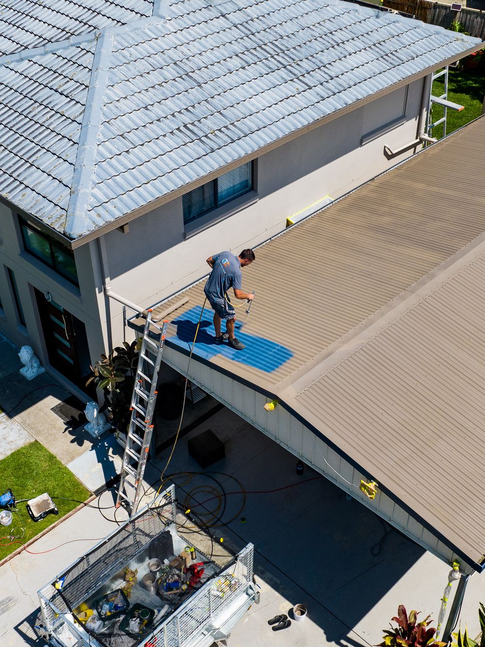 A series of aerial views showing a person installing solar panels on a residential rooftop during a sunny day.
