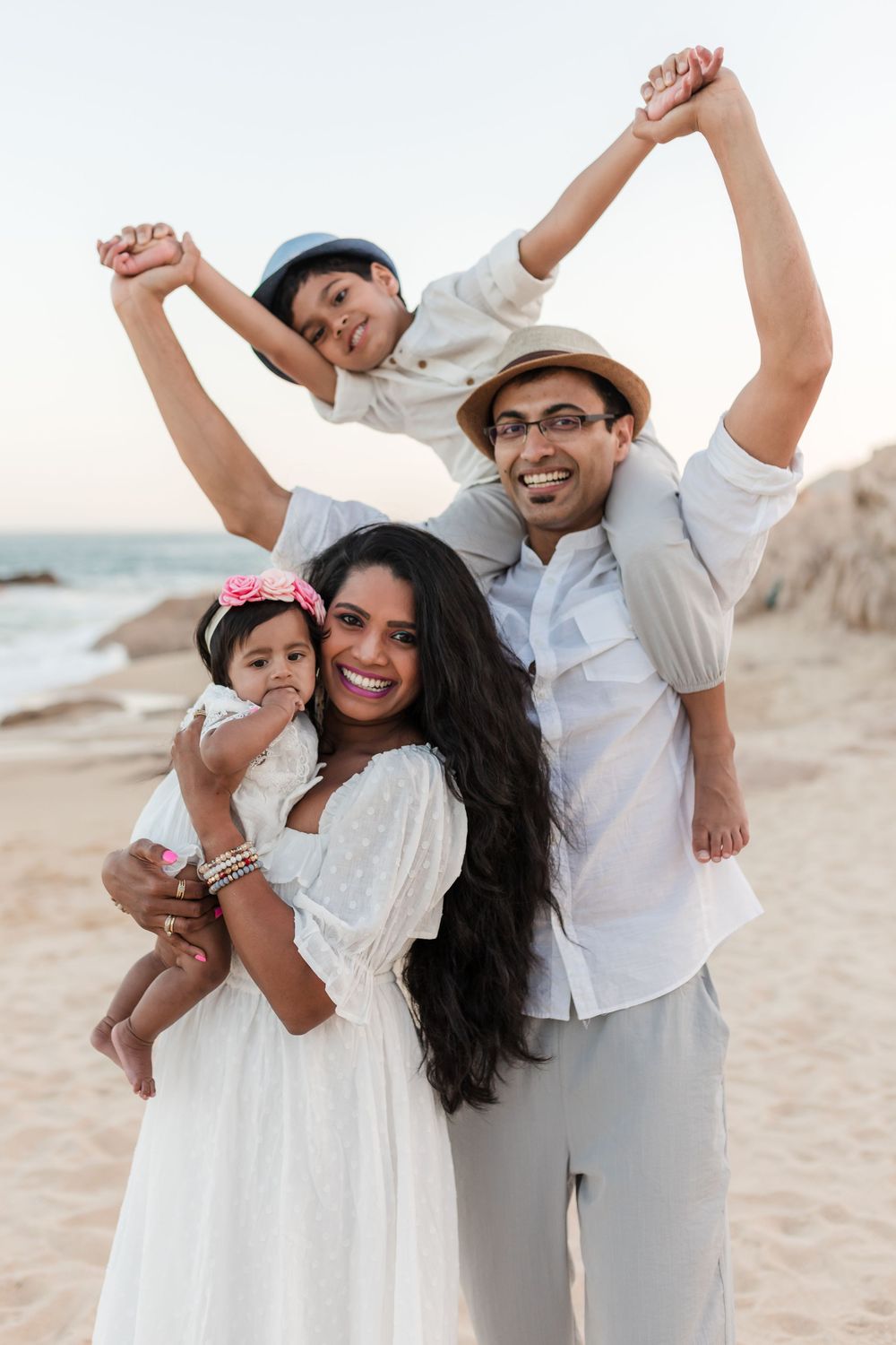 Parents holding hands with kids near the ocean