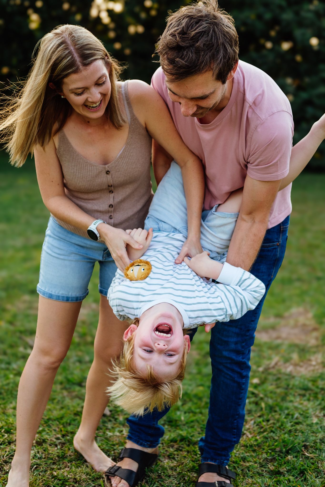 Parents playing joyfully with their five-year-old son