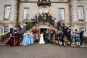 Wedding big group shot outside the Dalmahoy hotel near Edinburgh.  Guests on staircase throwing confetti on bride and groom.