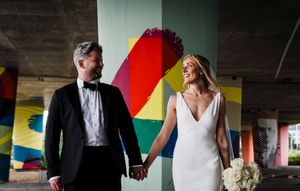 Groom and Bride standing under the Tay road bridge in Dundee after getting married at The Selkie, urban painted background