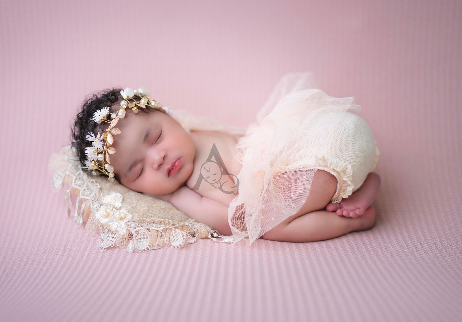 Delicate newborn photography setup with lace dress and floral headpiece.