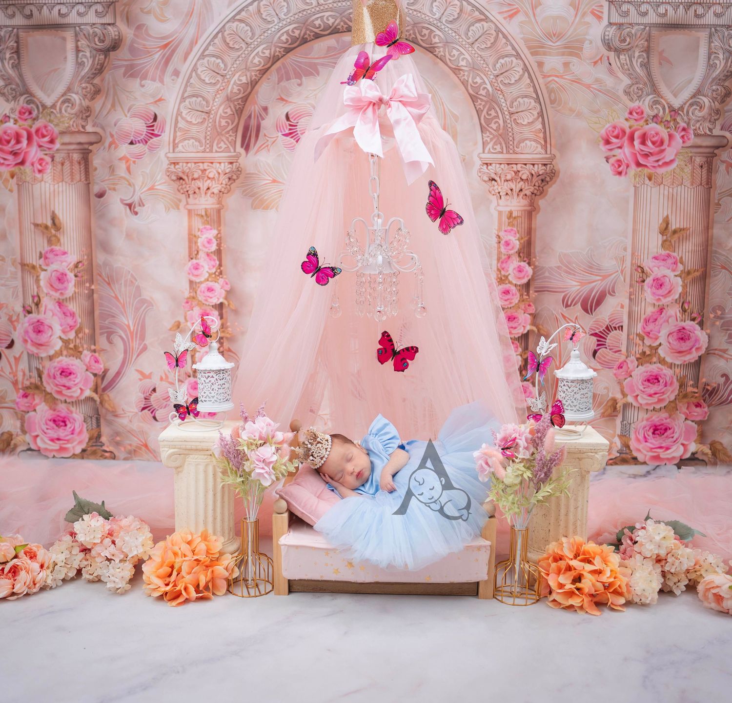 Sleeping baby in blue outfit under pink arch with butterflies and floral arrangements.
