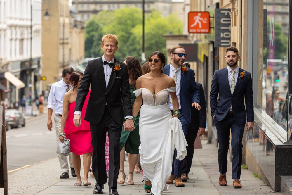 Bride, groom and guests walking up Park Street in Bristol