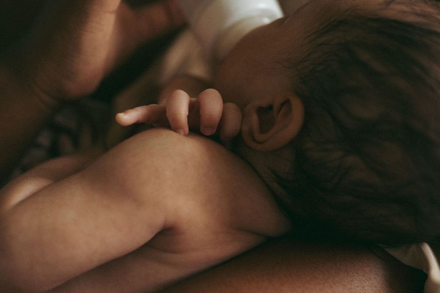 Intimate detail shot of a sleeping baby during a tender moment.