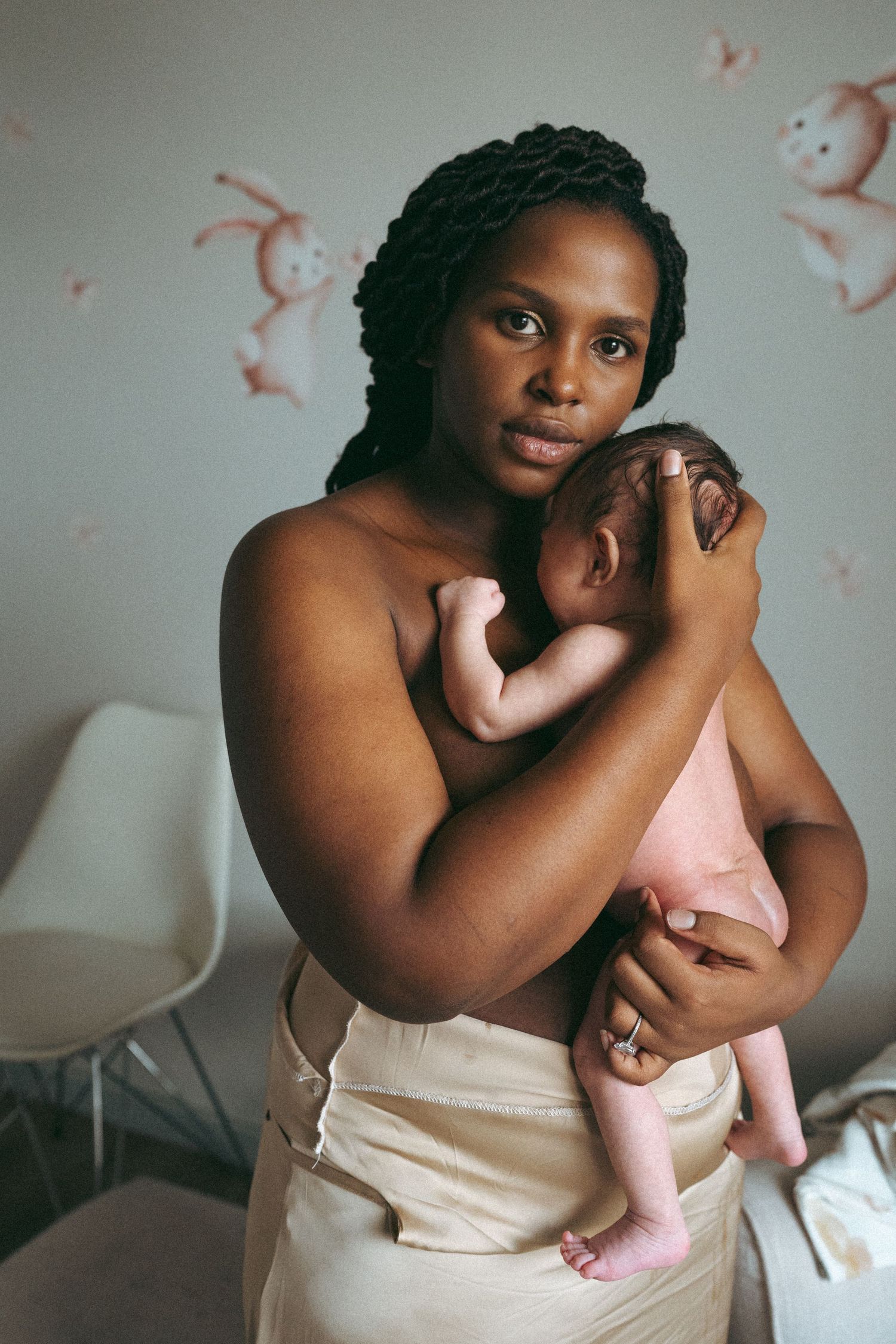 Intimate sequence of a parent bonding with their newborn baby against a light background.