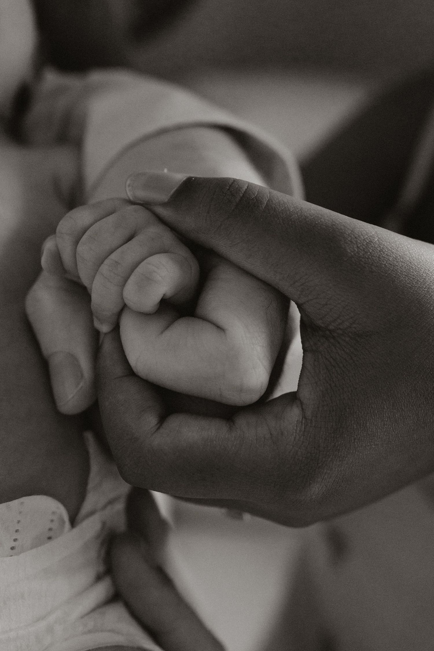 Close-up black and white images of intertwined hands showing connection and love.