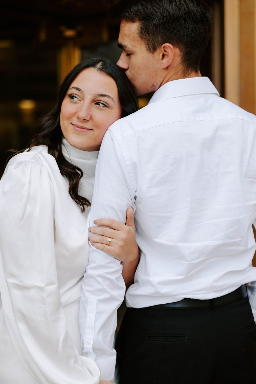 A couple in formal black and white attire embraces in a romantic sequence of candid photos.