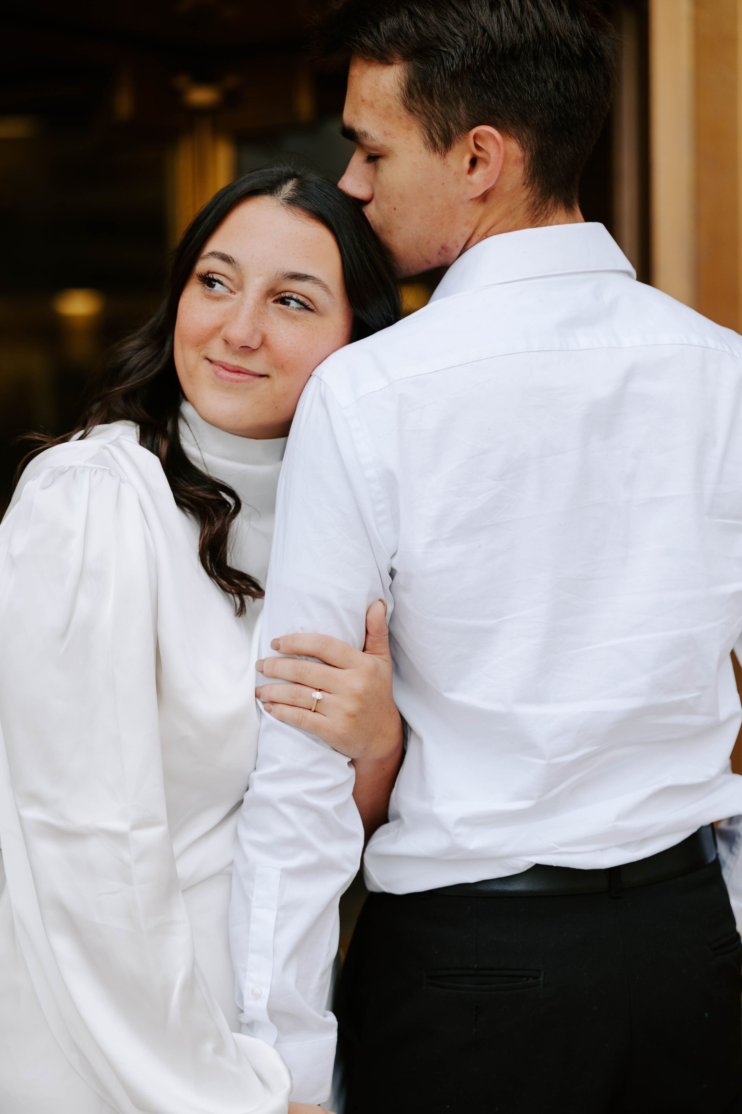 A couple in formal black and white attire embraces in a romantic sequence of candid photos.