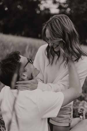 Black and white intimate portrait of couple sharing tender moment outdoors.