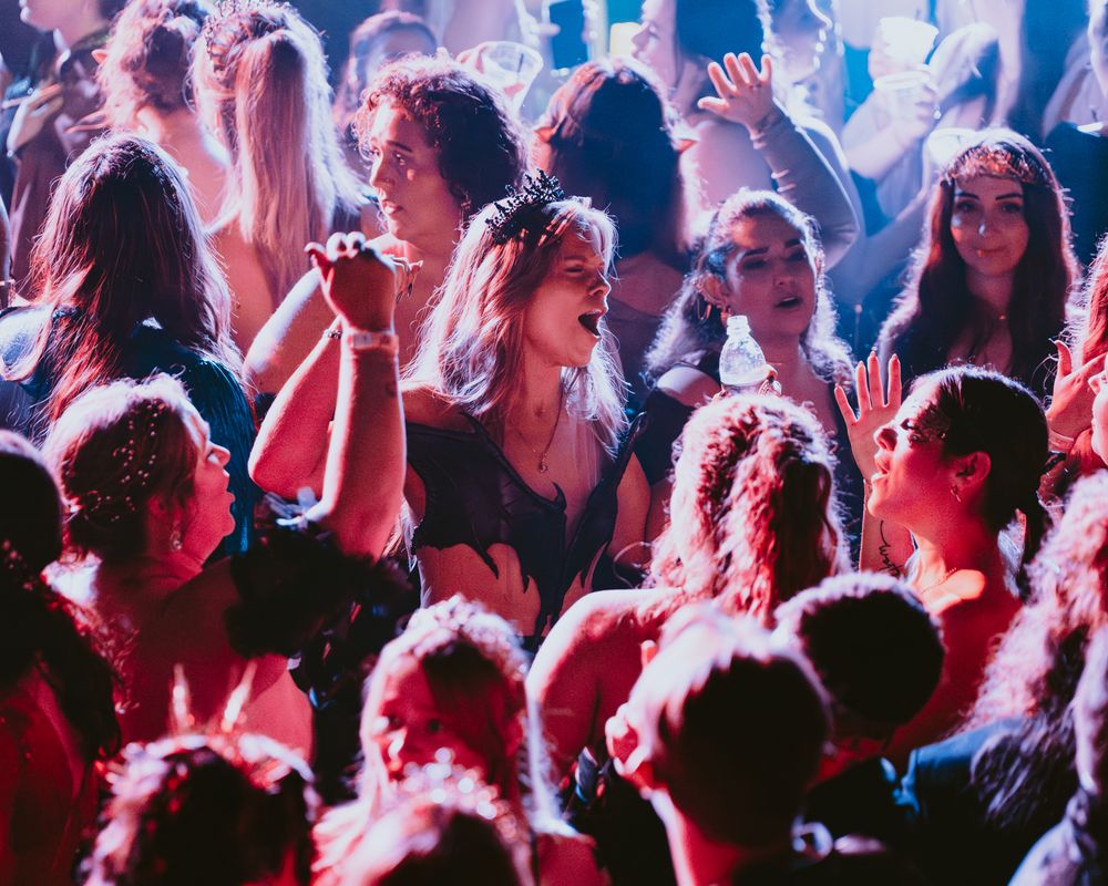 Concert crowd illuminated by blue and red stage lights during live performance.