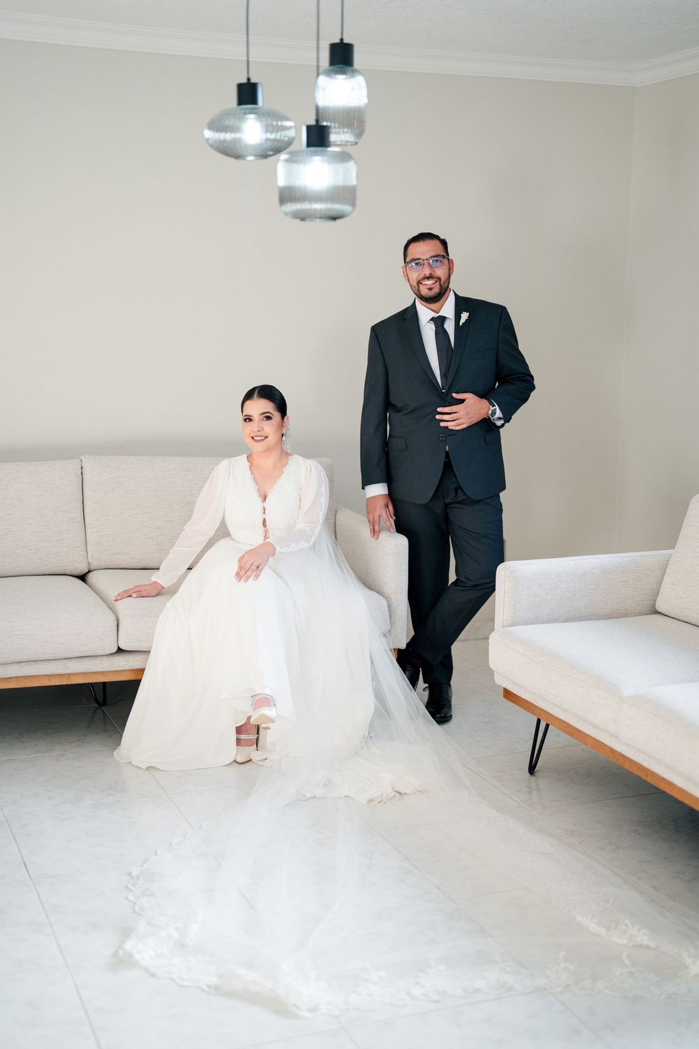 Modern interior scene with white sofa and formal-dressed people.