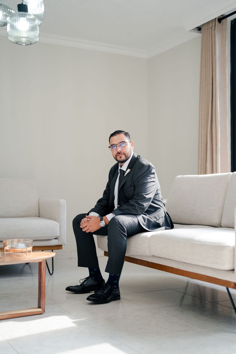 Modern minimalist room with white sofa and person in formal attire.